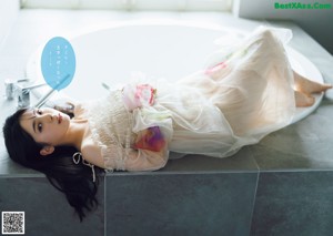 A person laying on a white plate covered in plastic.