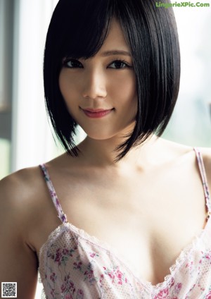 A woman in a blue and white lingerie sitting on a bed.