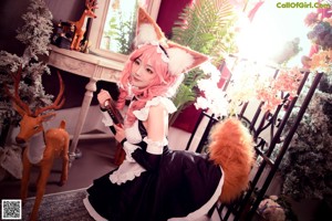 A woman in a maid outfit sitting on a chair.