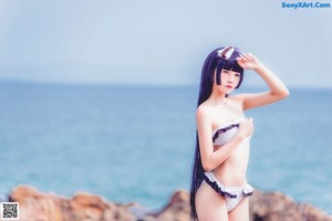 A woman in a bikini standing on the beach.