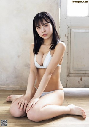 A woman in a white bra and panties posing for a magazine.