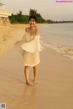 A woman in a bikini standing on a beach.