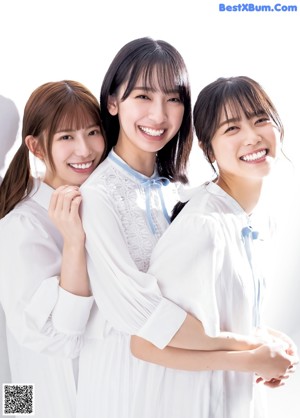 a group of young women standing next to each other on a bed