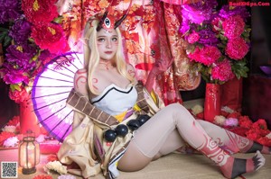 A woman in a kimono sitting on the floor with an umbrella.