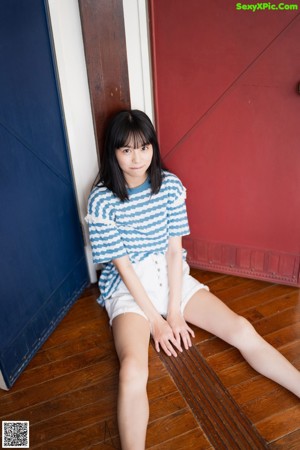 A woman in a white dress sitting on a bench.