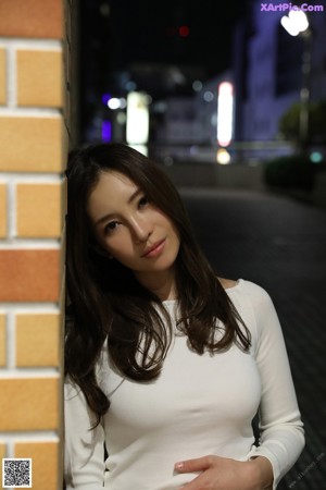 A woman sitting in a chair with her legs crossed.