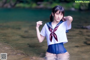 A woman in a school uniform walking down a path in a bamboo forest.
