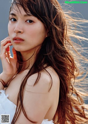 A woman in a white dress sitting on some steps.