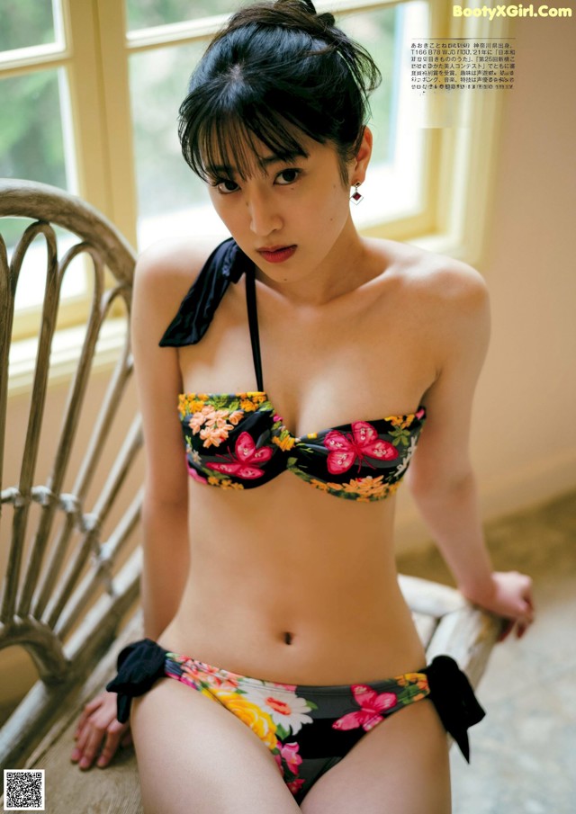 A woman in a bikini sitting on a chair.