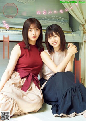 A couple of women laying on top of a wooden floor.