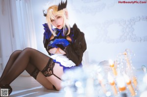 A woman in a black and blue outfit sitting on a table.