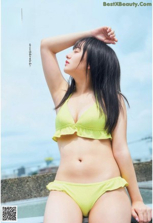 A woman in a yellow bikini posing for a magazine.