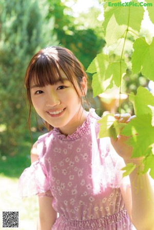 A woman in a yellow top is smiling at the camera.