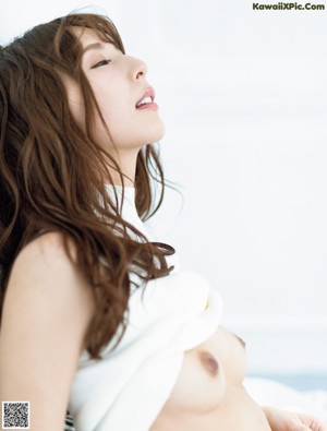 A naked woman with long brown hair and a red bracelet.