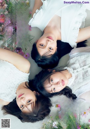 A group of three young women sitting next to each other.