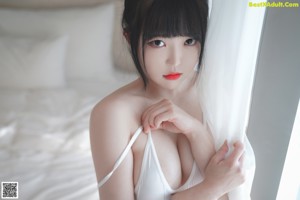 A woman in a white thong standing in a bathtub.