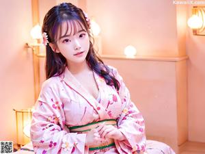 A woman in a blue kimono posing for the camera.