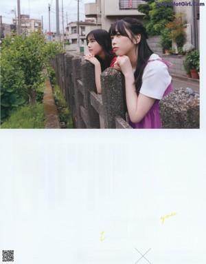 Two young women standing next to each other in front of a house.