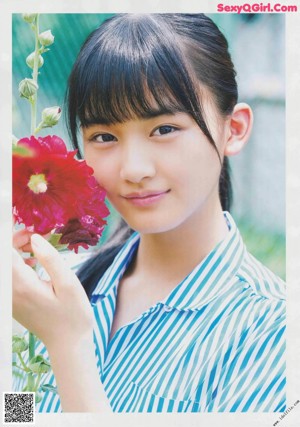 A young woman holding a white flower in her hands.