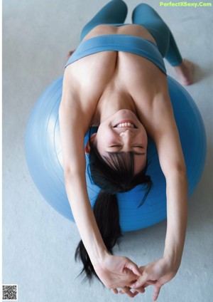 A woman sitting on top of an exercise ball.