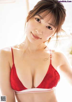 A woman in a bikini and jacket posing for a picture.