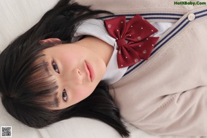 A woman with long black hair wearing a red bow tie.
