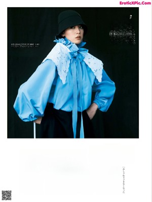 A woman in a black suit and boots posing for a magazine.
