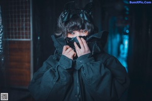 A woman in a black hoodie is sitting on a metal staircase.