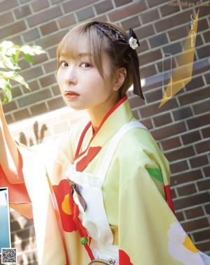 A woman in a purple and white kimono sitting on a stairway.